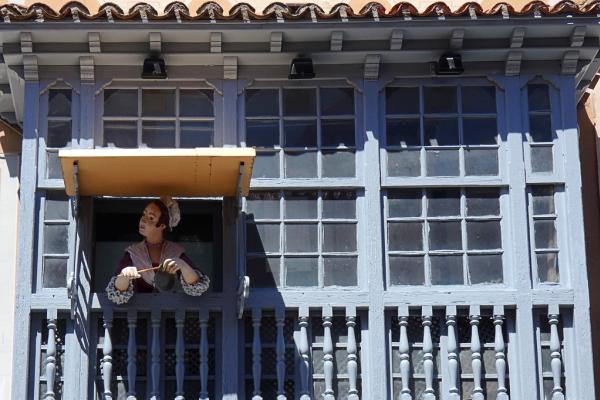 Balcón del restaurante de "Las Cocheras del rey" donde asoma un maniquí vestido de cocinera de época